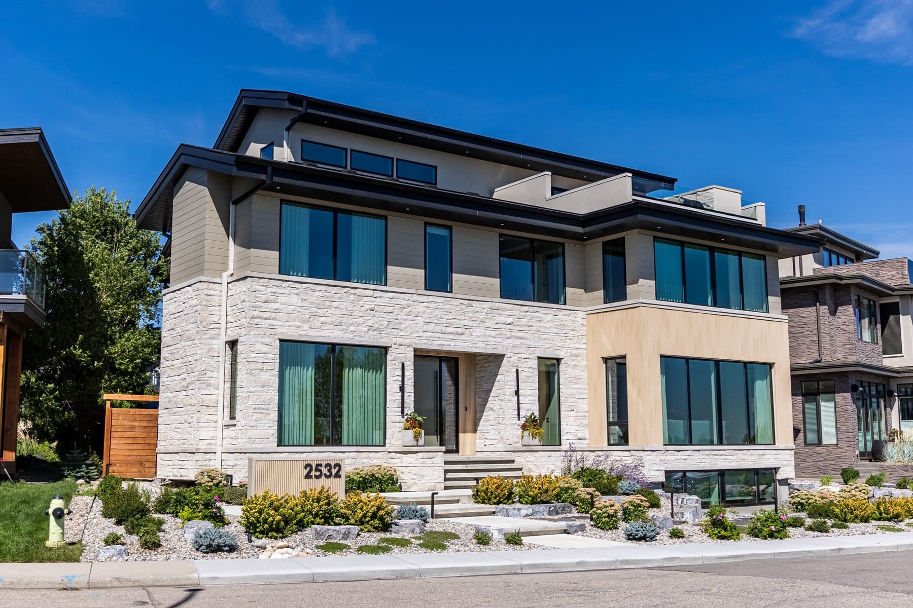 A recessed front entry with a full-height door, timber screen and stone threshold.