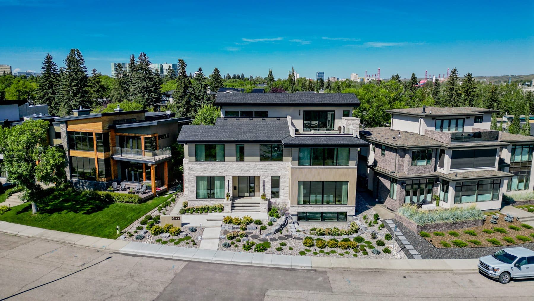 Aerial view of a Riverside house on its corner lot, with inner-city Calgary beyond.