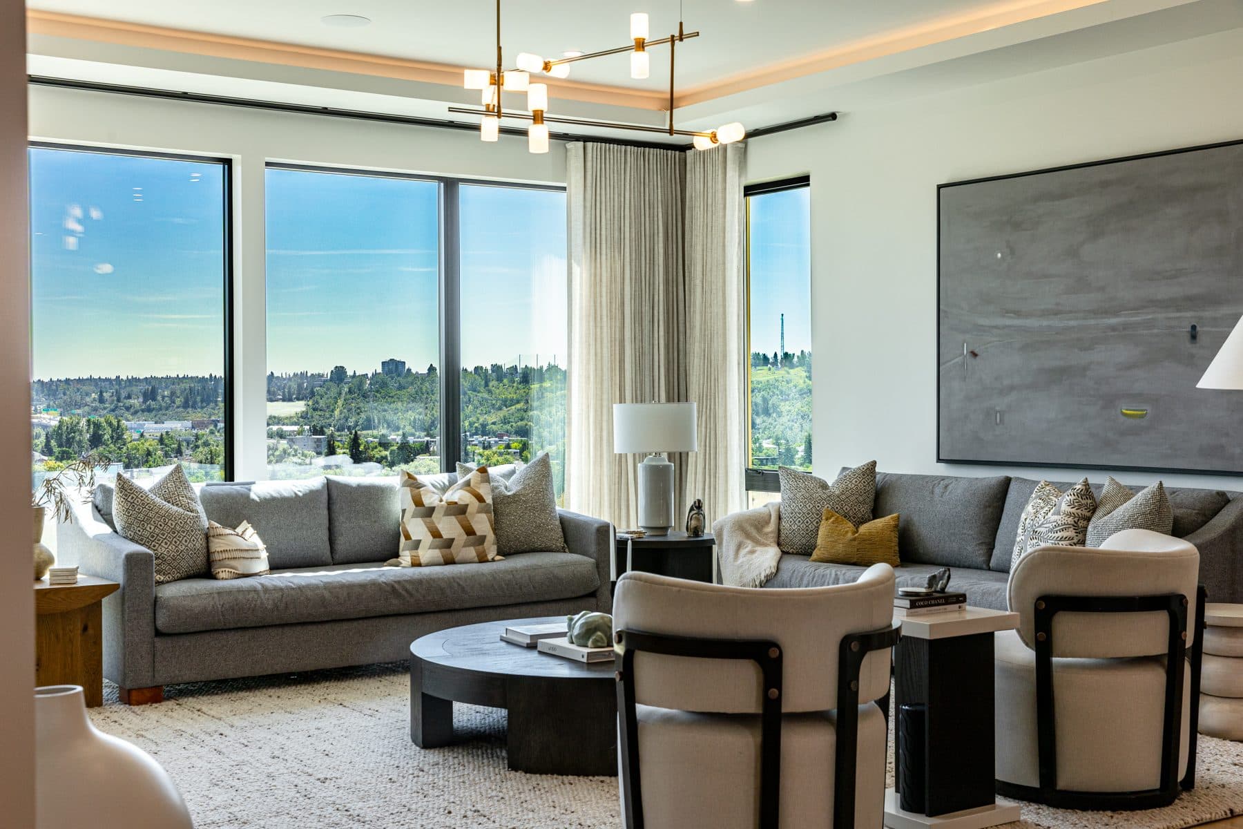 A living room behind floor-to-ceiling glazing, looking south across the escarpment to the city.