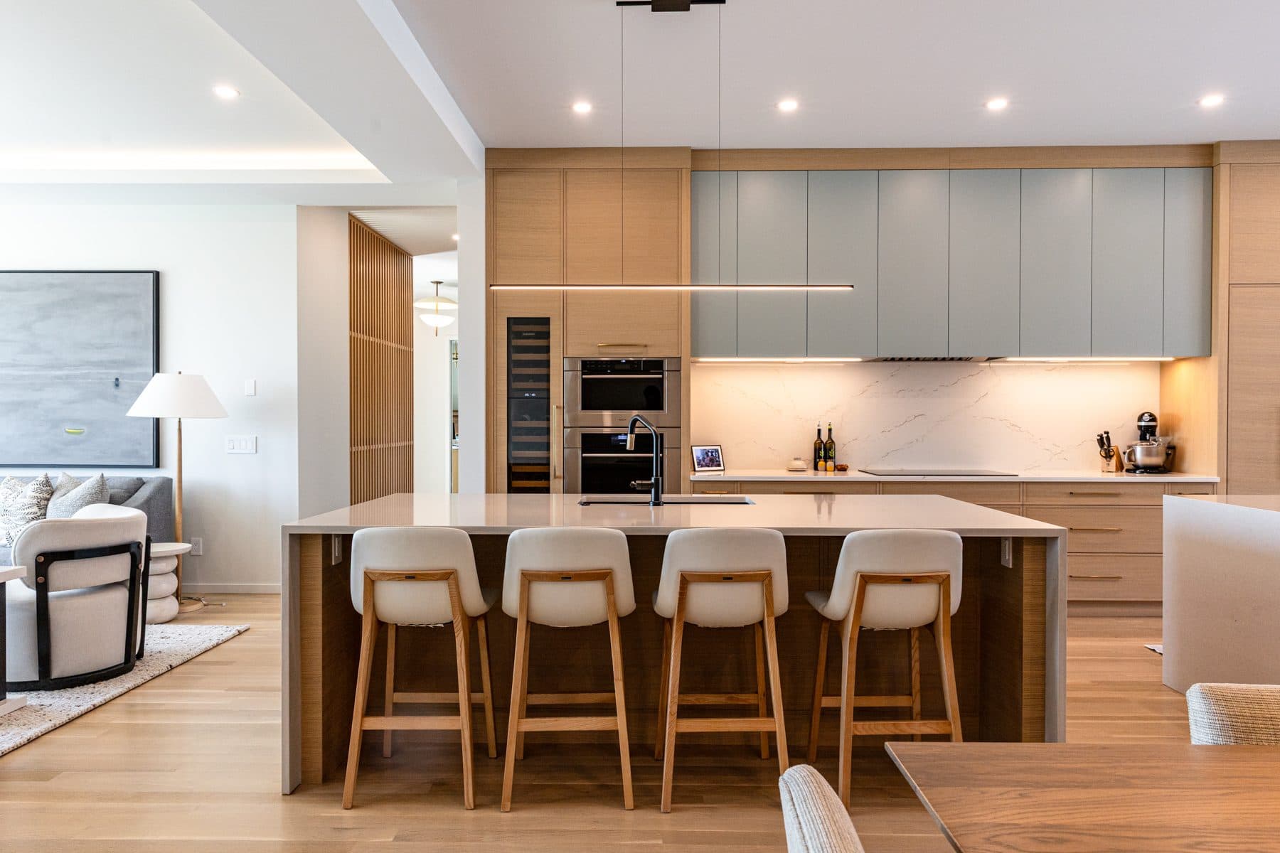 A kitchen seen from the hall, oak cabinetry continuing into the passage beyond.