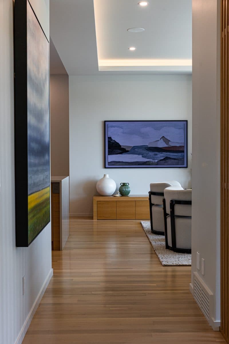 A hallway vignette — a low oak console beneath a framed landscape, against hand-finished plaster.