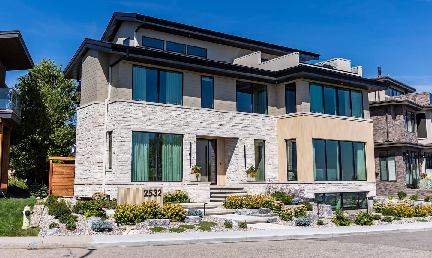 A recessed front entry with a full-height door, timber screen and stone threshold.